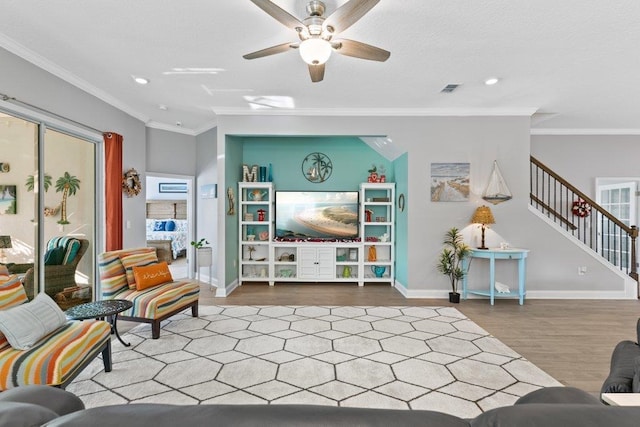 living room with hardwood / wood-style flooring, ornamental molding, and ceiling fan