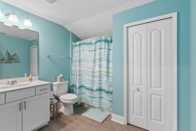 full bathroom with shower / bath combo, vanity, wood-type flooring, a textured ceiling, and toilet