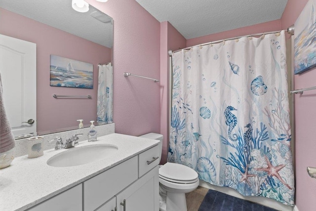 bathroom with vanity, walk in shower, a textured ceiling, and toilet