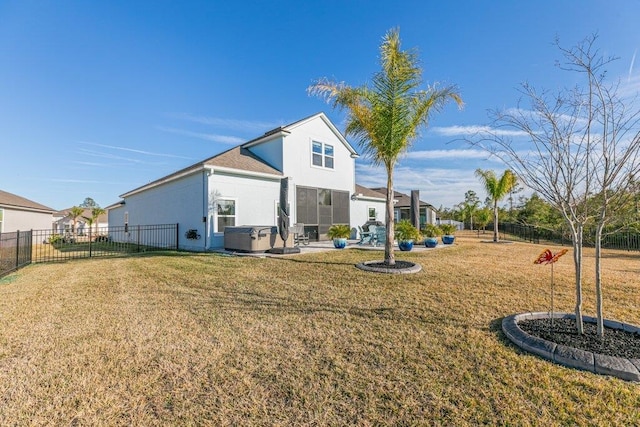 rear view of property featuring a hot tub, a yard, and central AC