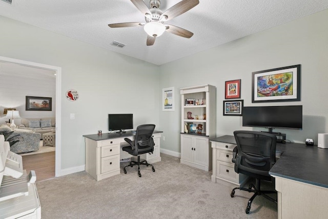 carpeted office space featuring a textured ceiling and ceiling fan