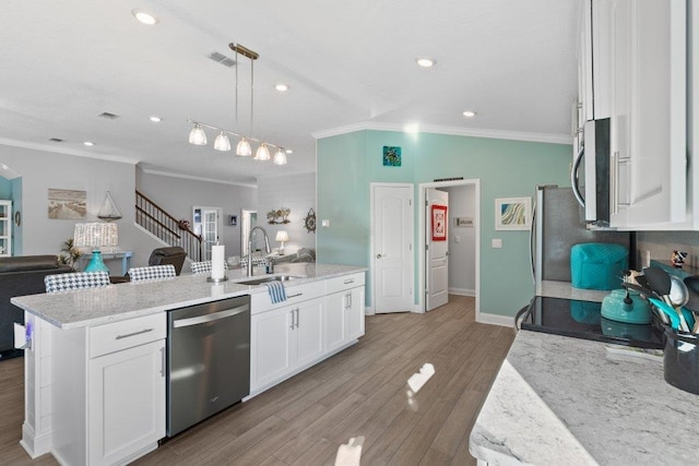 kitchen featuring white cabinetry, appliances with stainless steel finishes, sink, and pendant lighting