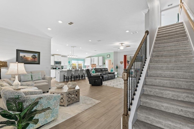 living room featuring lofted ceiling, ceiling fan, and light hardwood / wood-style flooring