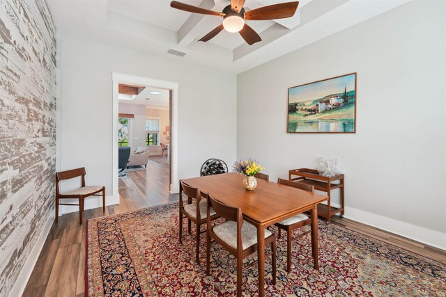 213 Pescado Dr, Saint Augustine, FL 32095 - dining room featuring coffered ceiling, a ceiling fan, wood finished floors, an accent wall, and beamed ceiling