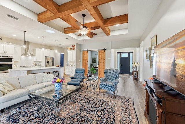 213 Pescado Dr, Saint Augustine, FL 32095 - living area featuring coffered ceiling, a barn door, light wood finished floors, beam ceiling, and ceiling fan