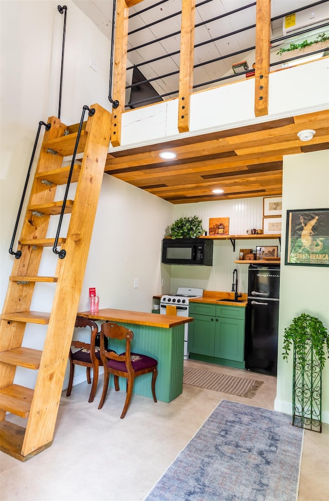 kitchen featuring sink, black appliances, a kitchen breakfast bar, and green cabinets