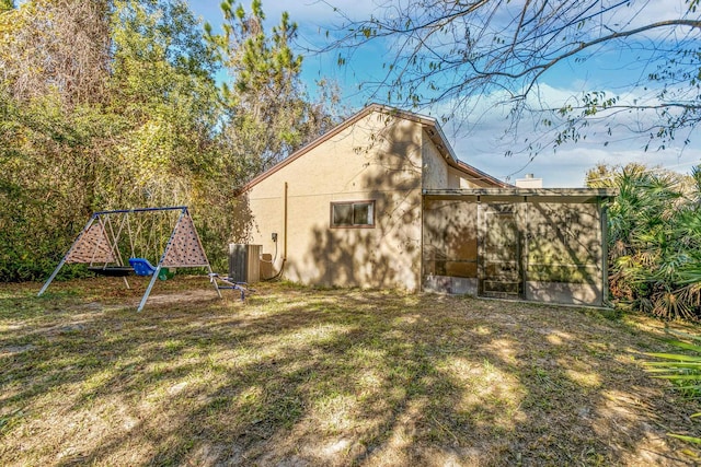 29 Hybiscus Ave, Saint Augustine, FL 32084 - view of home's exterior with stucco siding, a playground, and central air condition unit