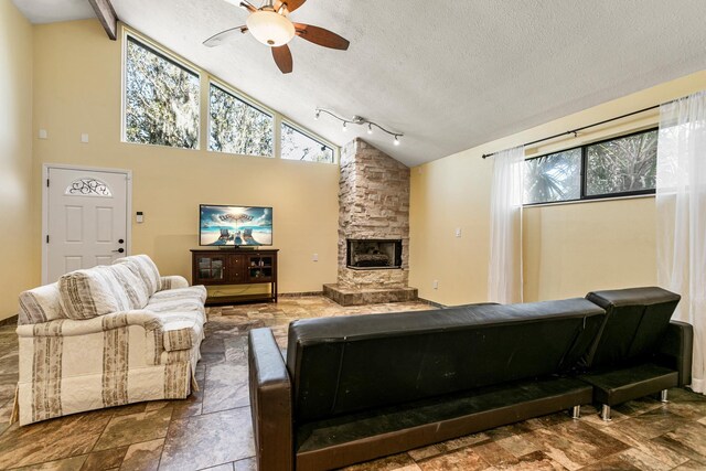 29 Hybiscus Ave, Saint Augustine, FL 32084 - living area with a ceiling fan, a textured ceiling, a stone fireplace, stone finish floors, and high vaulted ceiling