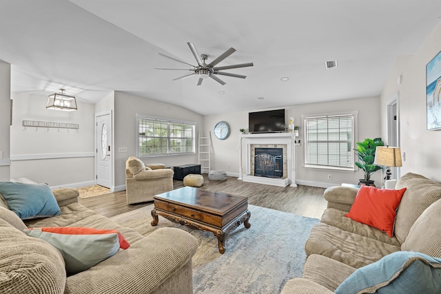 living room featuring a wealth of natural light, light hardwood / wood-style flooring, ceiling fan, and vaulted ceiling