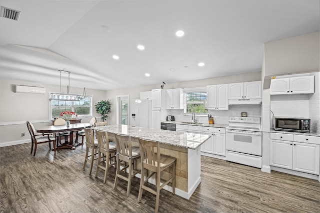 kitchen featuring white cabinetry, a healthy amount of sunlight, a kitchen island, and stainless steel appliances