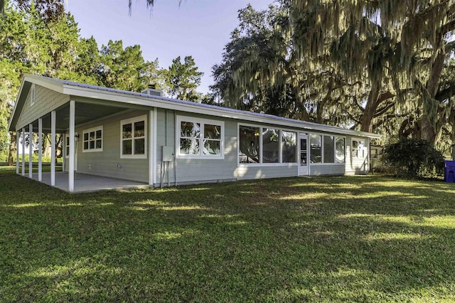 back of house with a yard and a patio