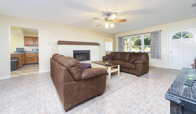 living room with a brick fireplace and ceiling fan