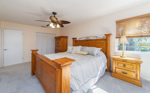 carpeted bedroom with ceiling fan and a closet