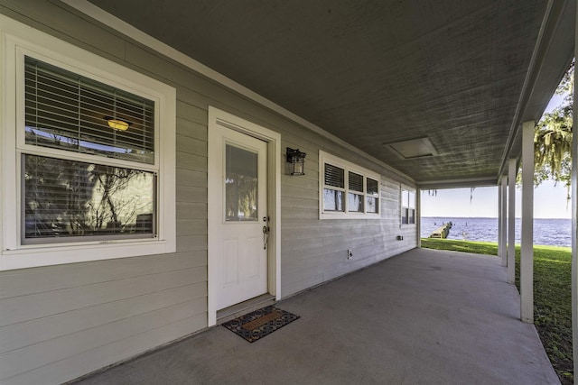 view of patio with covered porch and a water view