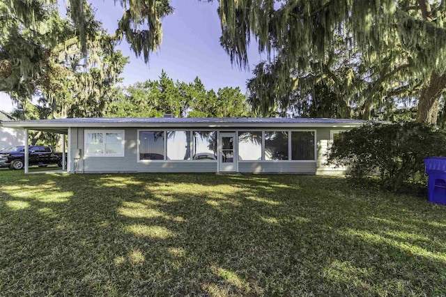 view of front of property with a front lawn and a carport