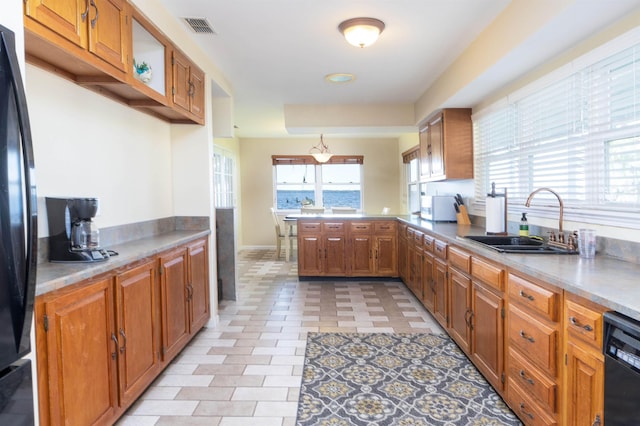 kitchen featuring kitchen peninsula, sink, light tile patterned flooring, and black appliances