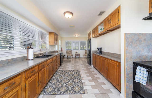 kitchen with black appliances, ventilation hood, sink, and light tile patterned floors