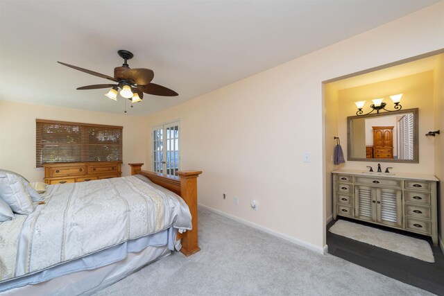 carpeted bedroom featuring ceiling fan and sink