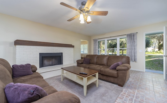 living room with ceiling fan and a fireplace