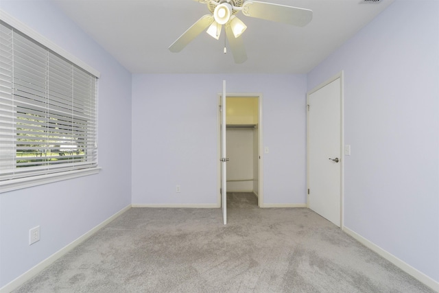 unfurnished bedroom featuring a closet, light colored carpet, and ceiling fan