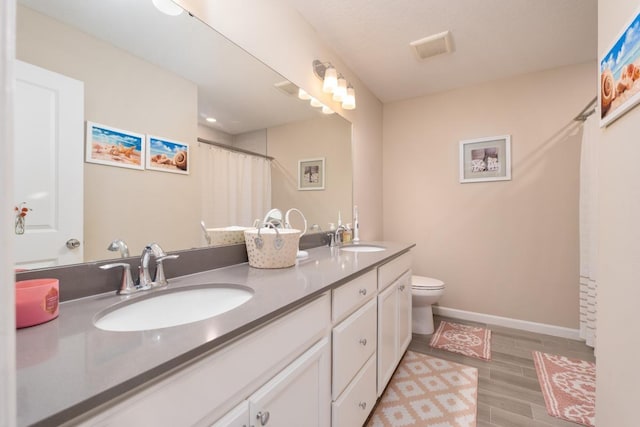 bathroom with hardwood / wood-style floors, vanity, and toilet