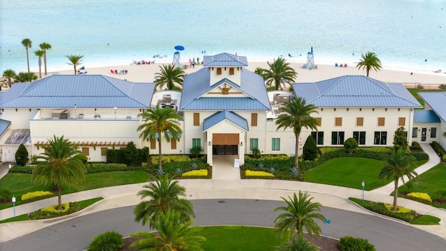 view of property with a water view and a beach view