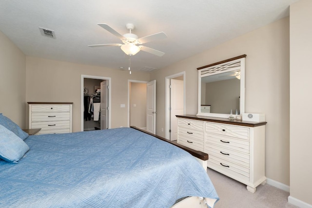 carpeted bedroom with ceiling fan, a spacious closet, and a closet