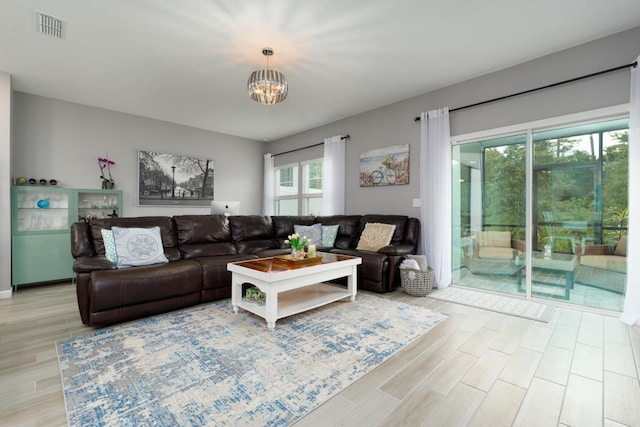 living room with a notable chandelier and light wood-type flooring