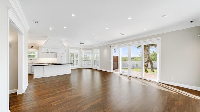 unfurnished living room featuring ornamental molding and dark wood-type flooring