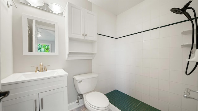 bathroom with vanity, toilet, and tiled shower