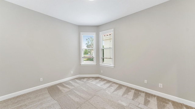 unfurnished room featuring light carpet