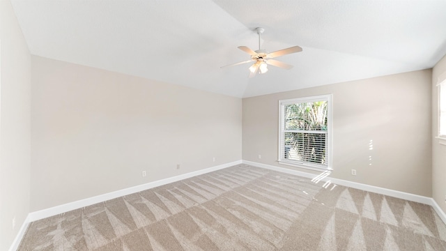 carpeted empty room with vaulted ceiling and ceiling fan