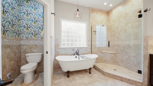 bathroom featuring tile patterned flooring, plus walk in shower, tile walls, and toilet