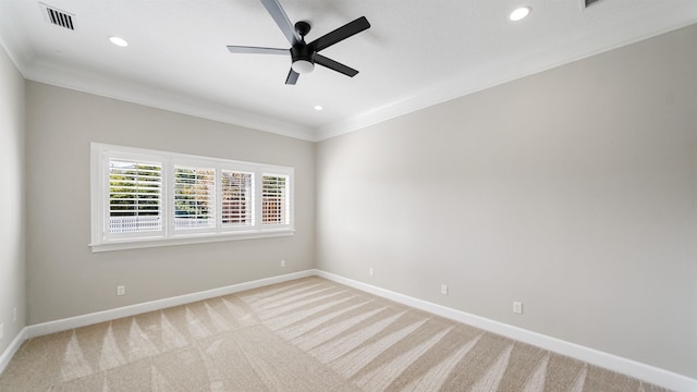 empty room featuring crown molding, light carpet, and ceiling fan