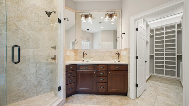 bathroom featuring an enclosed shower, vanity, and tasteful backsplash