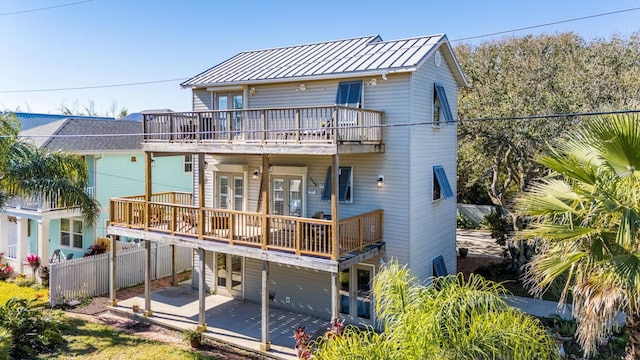 rear view of house with a patio and a balcony