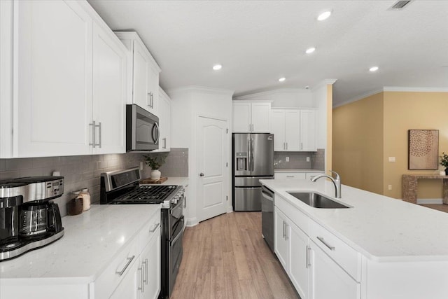 kitchen featuring white cabinetry, stainless steel appliances, sink, and a kitchen island with sink