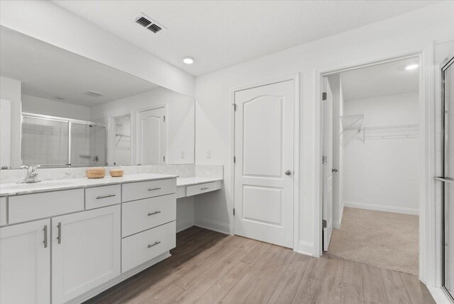 bathroom featuring vanity, hardwood / wood-style floors, and a shower with shower door