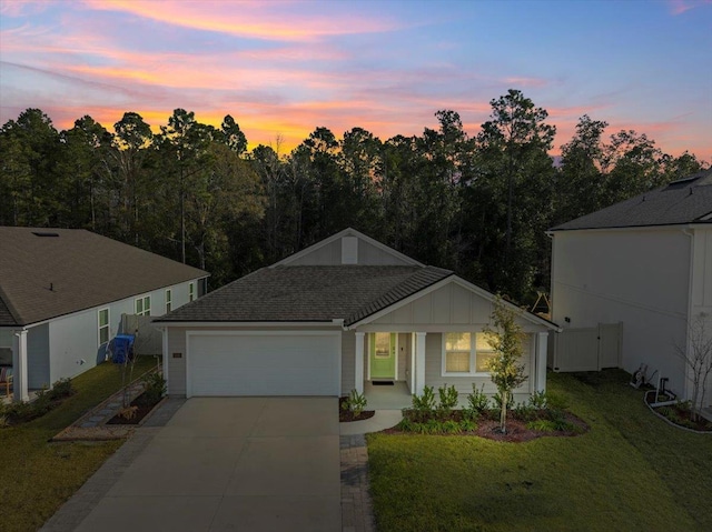 single story home featuring a garage and a yard