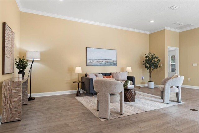 living room featuring crown molding and light hardwood / wood-style flooring