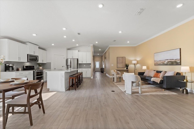 living room with sink, crown molding, and light hardwood / wood-style flooring