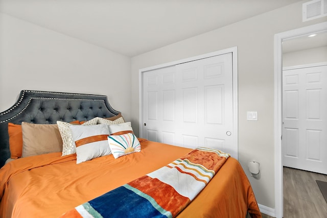 bedroom featuring wood-type flooring and a closet