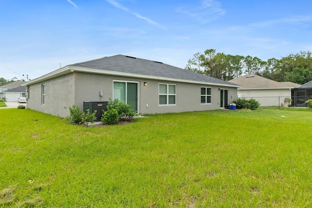 back of house with a yard and central AC unit