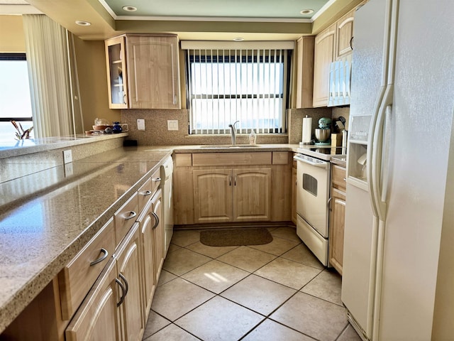 kitchen featuring sink, backsplash, white appliances, light brown cabinetry, and light tile patterned flooring