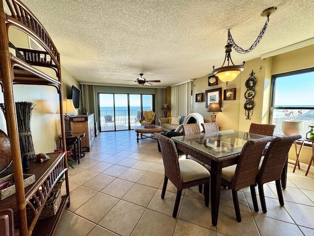 tiled dining space featuring a textured ceiling and ceiling fan