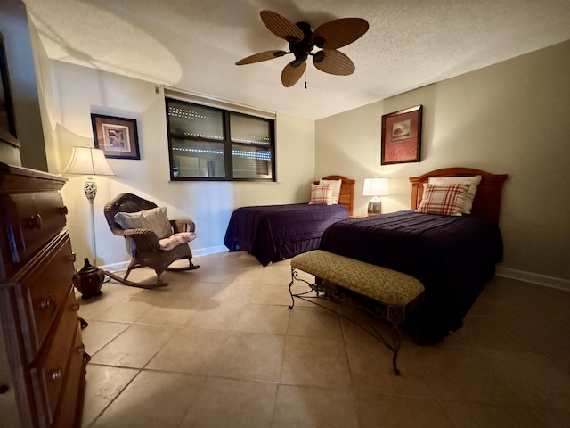 tiled bedroom featuring ceiling fan and a textured ceiling