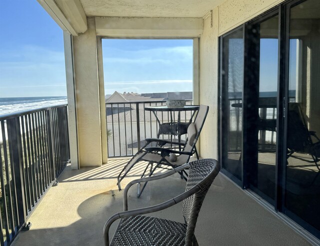 balcony with a water view and a beach view