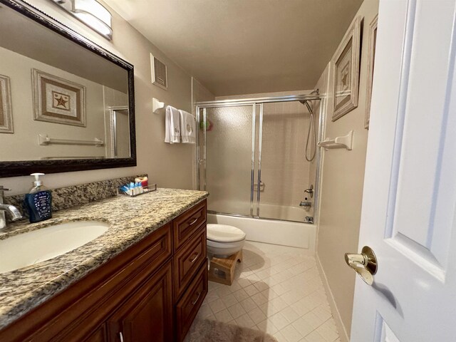 full bathroom with tile patterned floors, shower / bath combination with glass door, vanity, and toilet