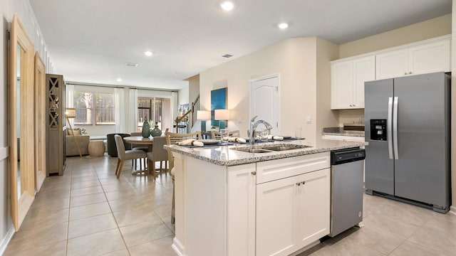 kitchen with a kitchen island with sink, sink, white cabinets, and appliances with stainless steel finishes