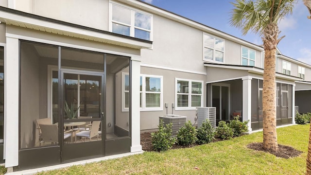 back of house featuring a yard, central AC unit, and a sunroom